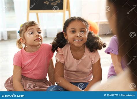 Cute Little Children Listening To Teacher. Kindergarten Playtime Activities Stock Photo - Image ...