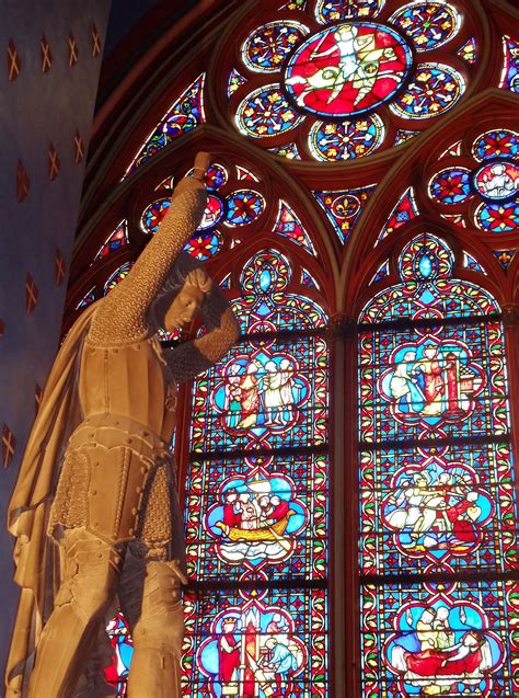 Statue & stained glass window inside Notre Dame Cathedral in Paris by Bill & Norma Danforth ...