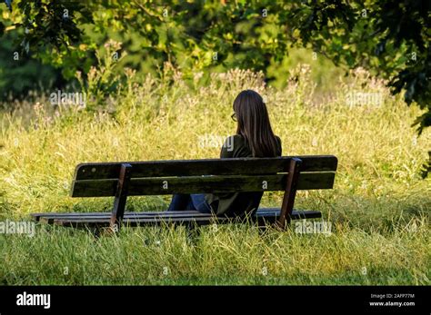 Girl sitting alone in a park bench hi-res stock photography and images ...