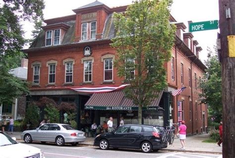 cars are parked on the side of the road in front of an old brick building