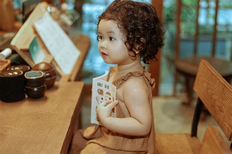 Little Girl with a Book Sitting at the Counter · Free Stock Photo