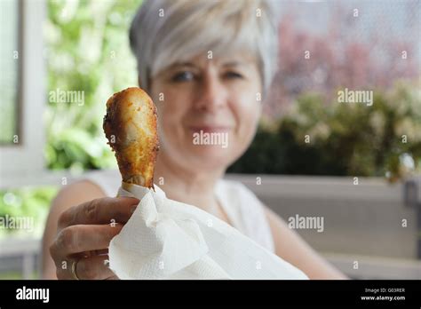 Woman holding a freshly grilled chicken thighs Stock Photo - Alamy