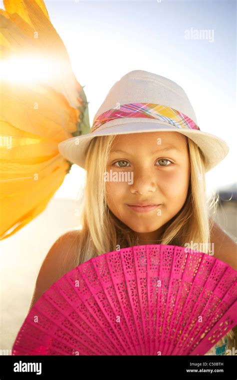 Mixed race girl with large flower and fan Stock Photo - Alamy