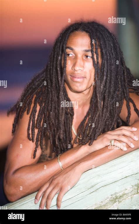 Young Jamaican man with dreadlocks leaning against pier Stock Photo - Alamy