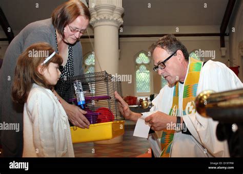 Priest blessing an animal during a pet blessing ceremony in church. SE ...