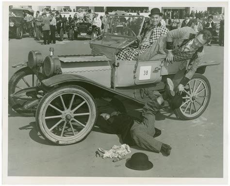 an old black and white photo of people in a car with the driver leaning over