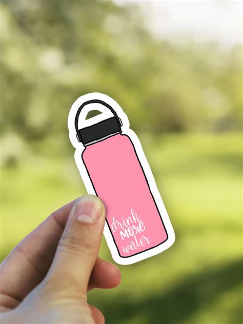 a hand holding a pink water bottle sticker