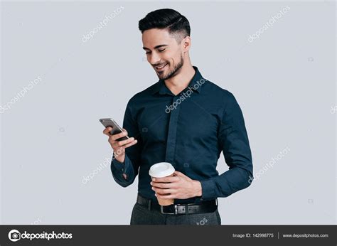 Man holding mobile phone and coffee mug Stock Photo by ©gstockstudio 142998775