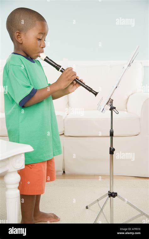 African boy playing a recorder with sheet music Stock Photo - Alamy