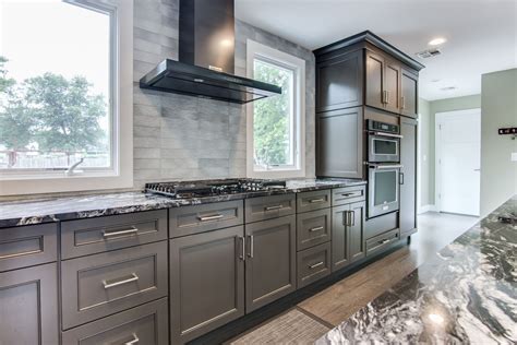 Black Stainless Steel KitchenAid Rangehood in between windows in a gray ...