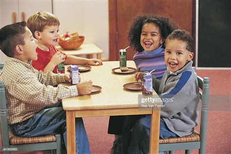 Four Nursery School Children Sitting At A Table For A Snack High-Res Stock Photo - Getty Images