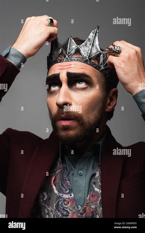 man in halloween makeup adjusting vampire king crown on head isolated on grey Stock Photo - Alamy