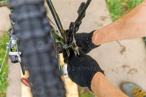 Bike mechanic man repairs bicycle in bicycle repair shop, outdoor. Hand ...