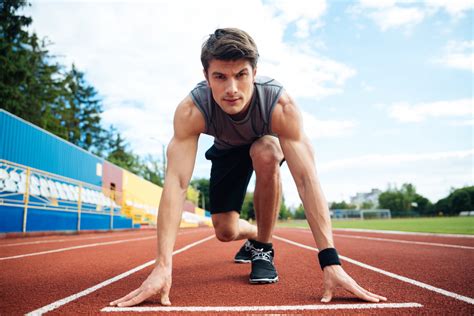 Young concentrated male athlete about to start a sprint and looking at camera Royalty-Free Stock ...