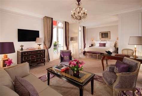 a living room filled with furniture and a chandelier hanging from the ceiling next to a bed