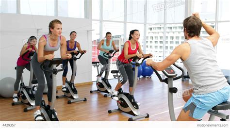 Spinning Class In Fitness Studio Led By Energetic Stock video footage | 4429357