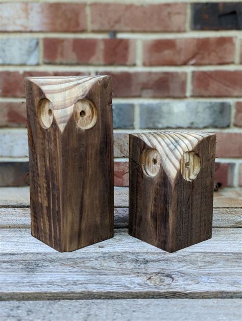 two wooden blocks with faces carved into them