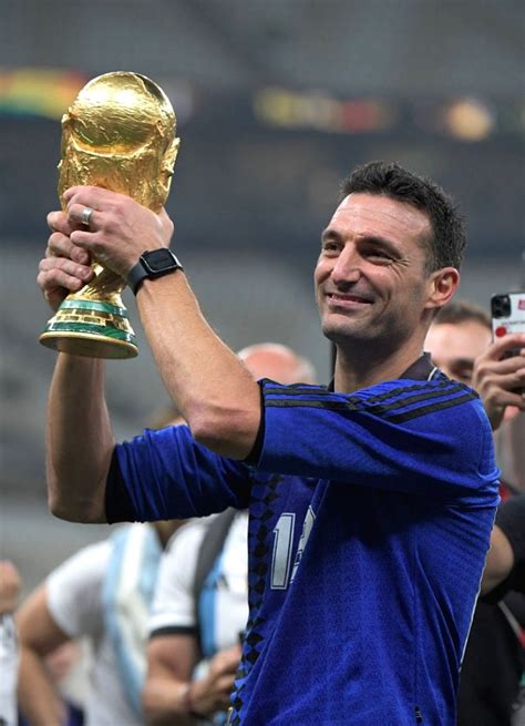 :Lusail:Argentina's head coach Lionel Scaloni holds up the trophy after winning.