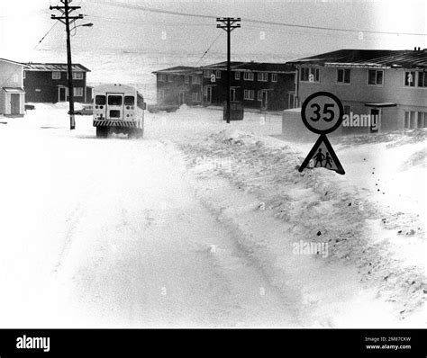 A base bus travels through snow at the Coral Sea housing area. Base: Naval Air Station, Keflavik ...