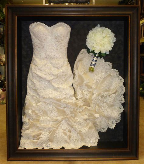 Framed wedding dress and bouquet framed by Floral Keepsakes. This dress has been gathered up to ...