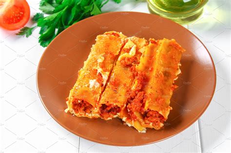 Traditional Italian pasta cannelloni. Baked tubes stuffed with minced meat with parmesan cheese ...