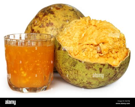 Medicinal Bael fruit with juice over white background Stock Photo - Alamy