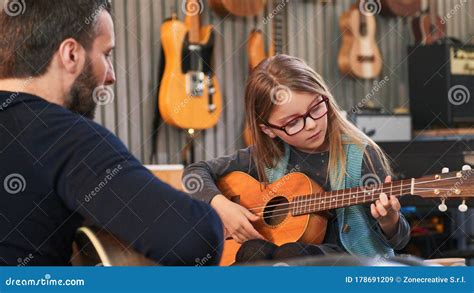 Dad Teaching Guitar and Ukulele To His Daughter.Little Girl Learning Guitar at Home.Close Up ...