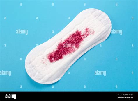 Feminine hygiene pad with red glitter on blue background. First menstrual period concept Stock ...