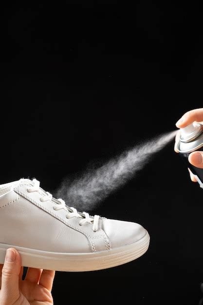 Premium Photo | Applying a waterrepellent hydrophobic spray to white women's sneakers Protection ...