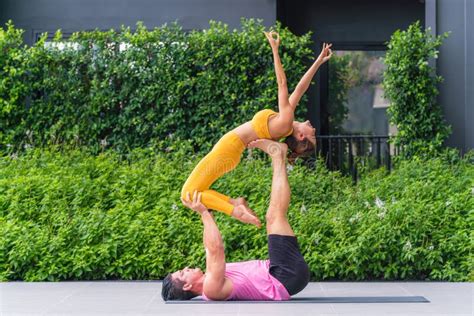 Athletic Couple Practicing Acro Yoga or Yoga Partner Together in ...