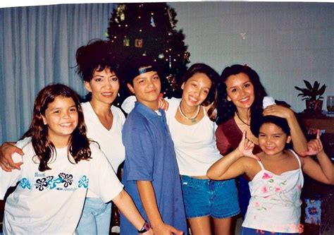 a group of people standing next to each other in front of a christmas tree