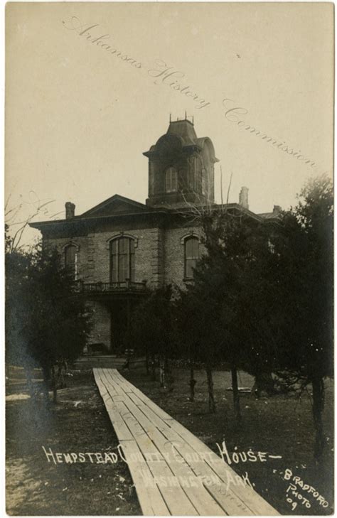 an old photo of a house with a wooden walkway leading to it