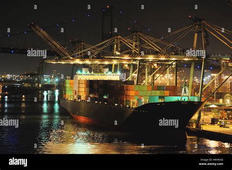 Cargo ship in port with containers at night Stock Photo - Alamy