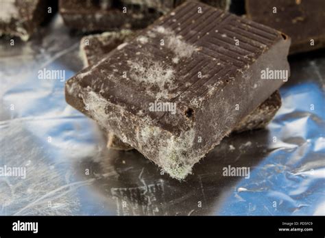 Moldy chocolate in the original packaging. Out-dated food products used for desserts. White ...