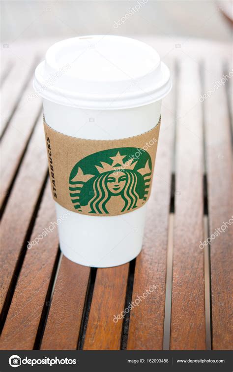 Starbucks take away coffee cup with brand logo on wood table – Stock ...