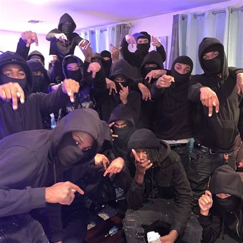 a group of people in black hoods pointing at the camera