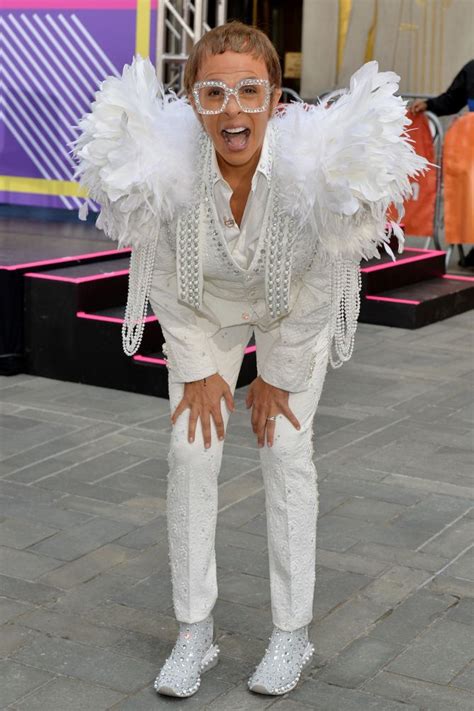 a man dressed in white poses for the camera