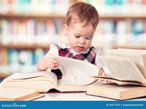 Happy Baby Girl Reading A Book In A Library Stock Photo - Image: 39611324