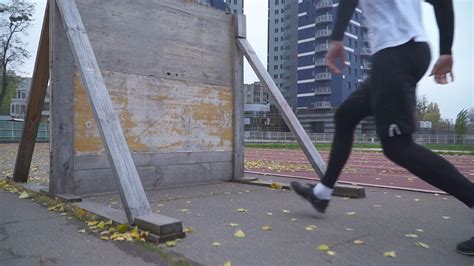 Young man in sportswear overcomes an obstacle in the sports field Running athlete overcomes an ...