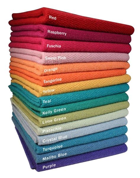 a stack of towels with different colors and names on them, all stacked up together