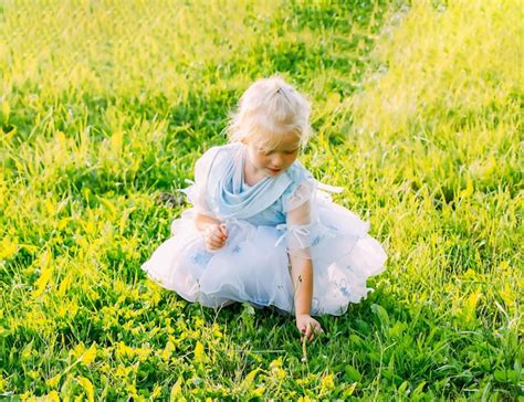 Premium Photo | Little girl on green grass on a warm summer day