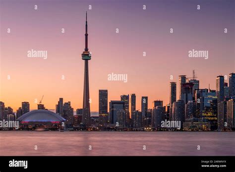 Toronto Skyline at sunset featuring the CN Tower across Lake Ontario, Toronto, Ontario, Canada ...