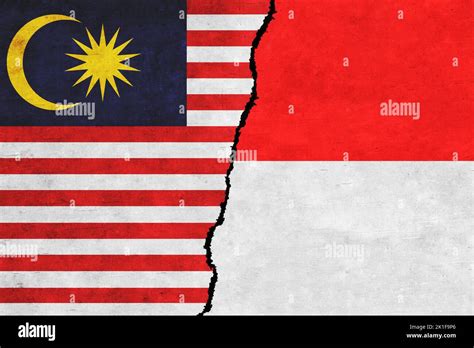 Indonesia and Malaysia flags on a wall with crack. Indonesia and ...