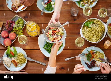 people eating salad at table with food Stock Photo - Alamy