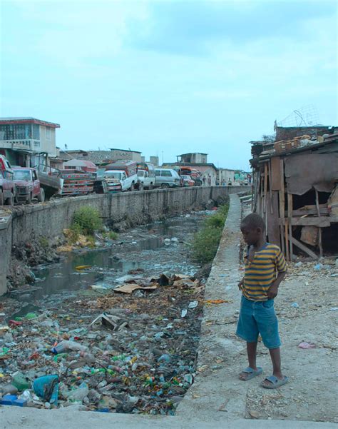 A boy looks into a canal in Port-au-Prince, Haiti. (May 2008, OC) : r/pics