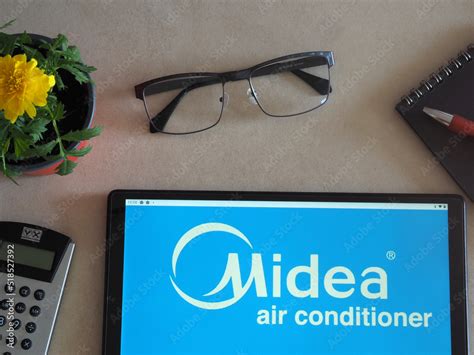 In this photo illustration, Midea Group logo seen displayed on a tablet Stock Photo | Adobe Stock