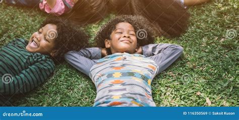 Happy Children Kids Laying on Grass in Park Stock Image - Image of ...