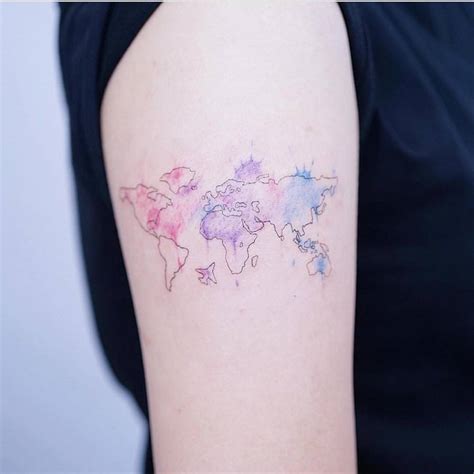 Watercolor world map tattoo on the upper arm.