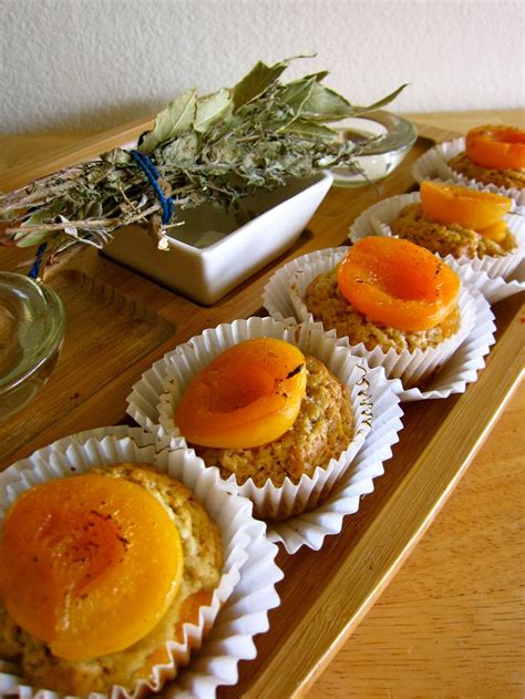 several cupcakes are lined up on a tray with dried herbs in the background