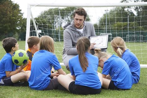 Entrenador dando charla de equipo con el equipo de fútbol de la escuela ...